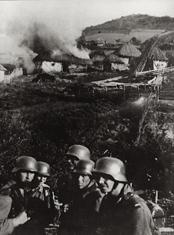 German soldiers after setting fire to a Serbian village, 1941.